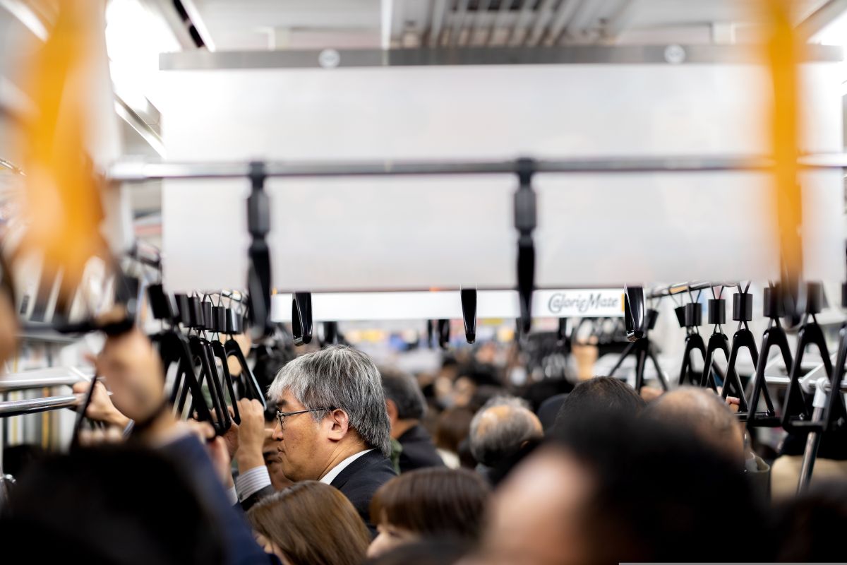 Passengers riding quietly on a crowded Japanese commuter train