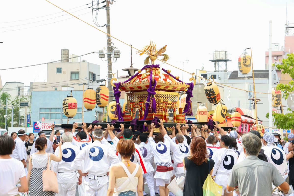 People carrying a traditional portable shrine during a Japanese local festival