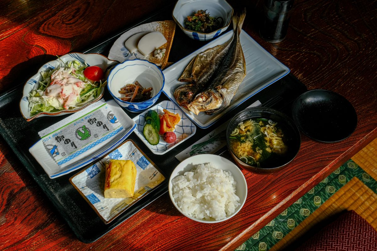 Traditional Japanese breakfast with rice, grilled fish, miso soup, and side dishes