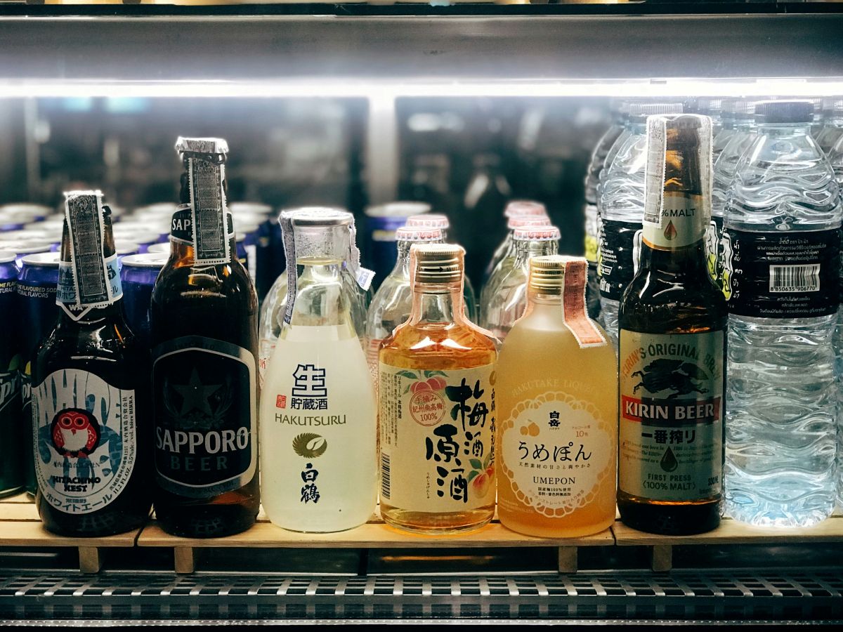 Glass of Japanese plum wine with fresh ume fruits on a wooden table