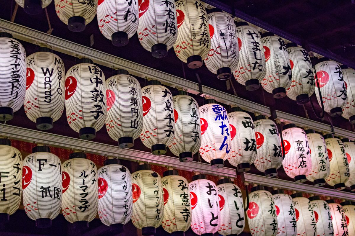 Traditional Japanese paper and stone lanterns glowing at a historic shrine