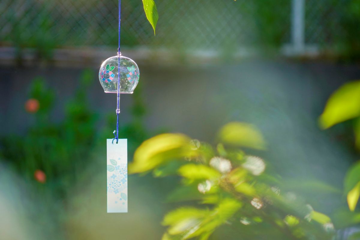 Colorful Japanese glass wind chimes hanging in a summer breeze
