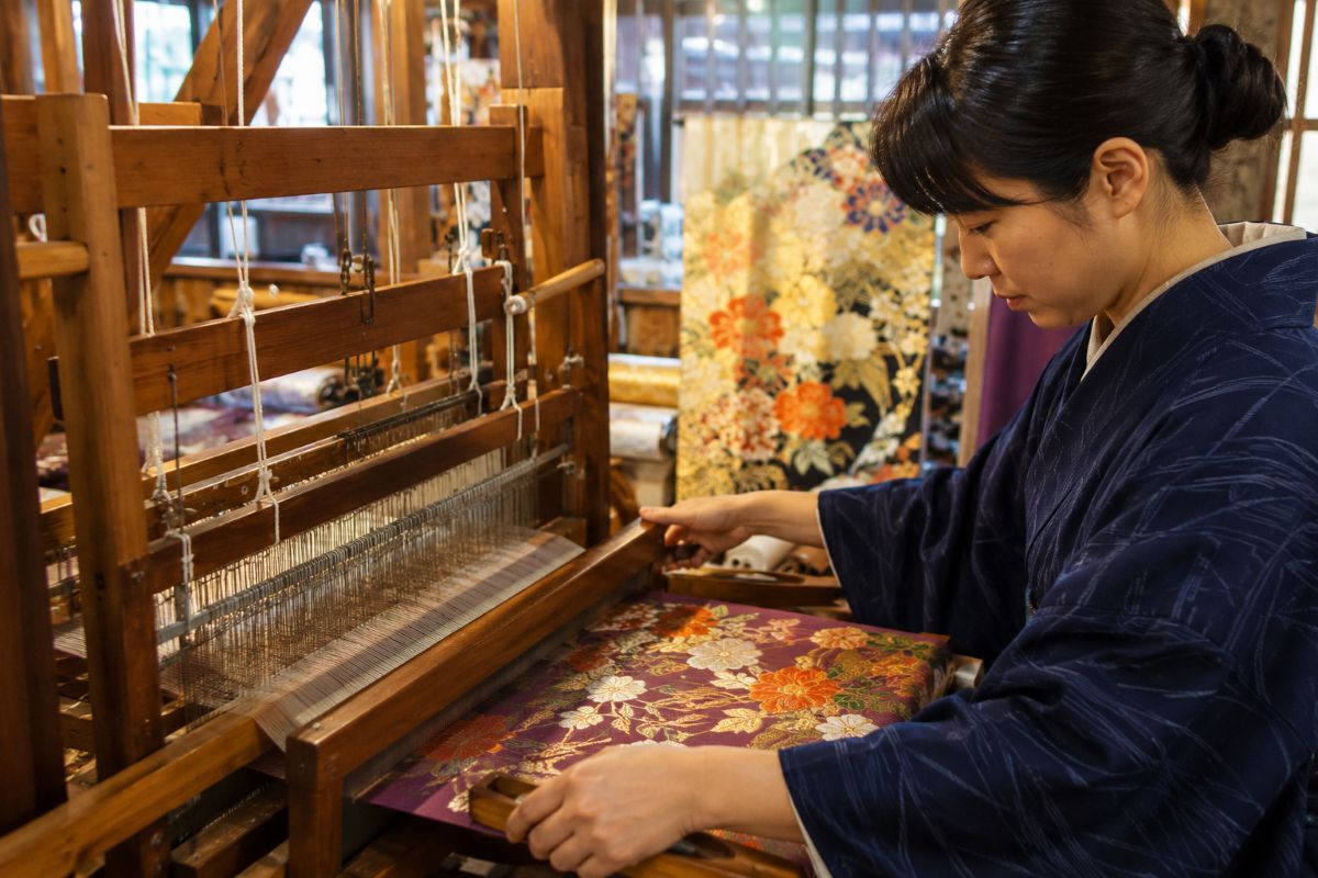 Japanese artisan creating traditional silk textiles on a wooden loom