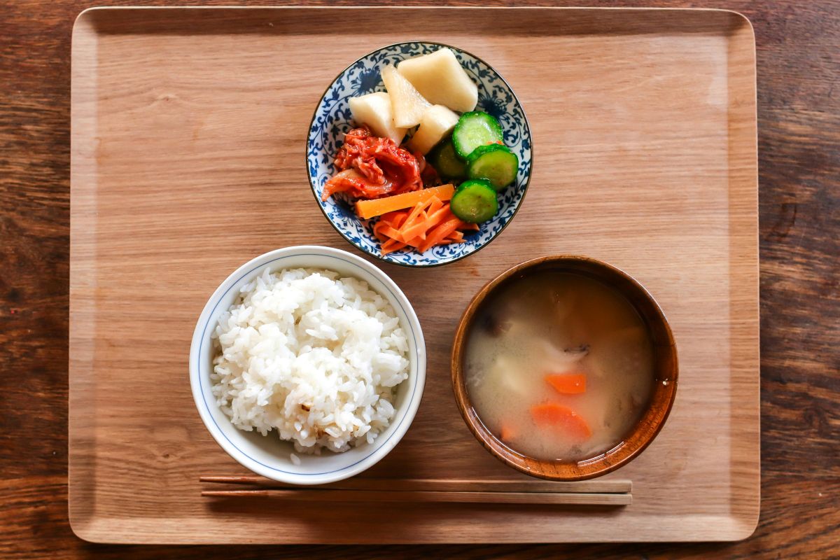 A Japanese family placing their hands together and saying Itadakimasu before eating.