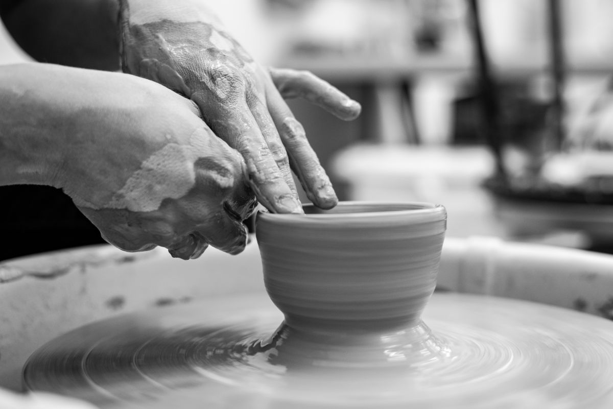 Traditional Japanese handmade pottery including tea cups, bowls, and ceramic plates displayed in a pottery workshop.
