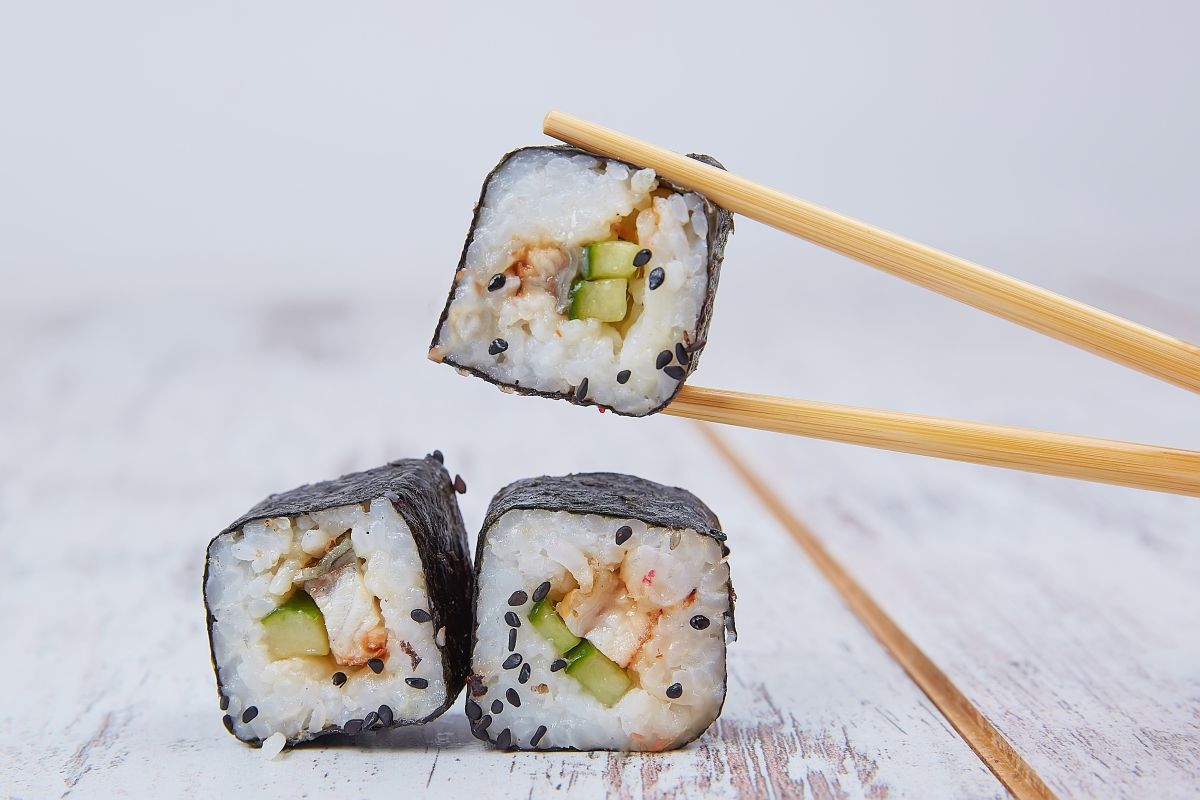 A Japanese family enjoying a traditional meal while skillfully using chopsticks.