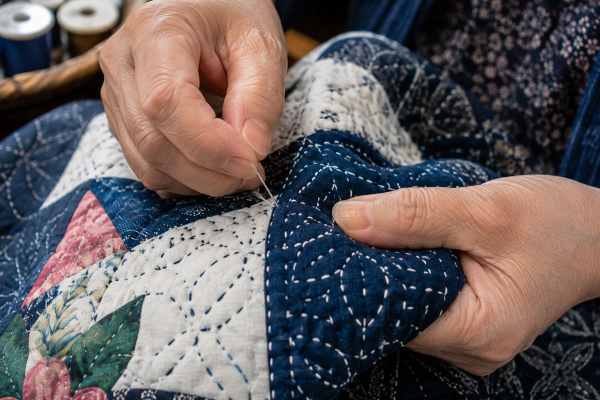 Japanese artisan creating a handmade quilt with traditional sashiko stitching