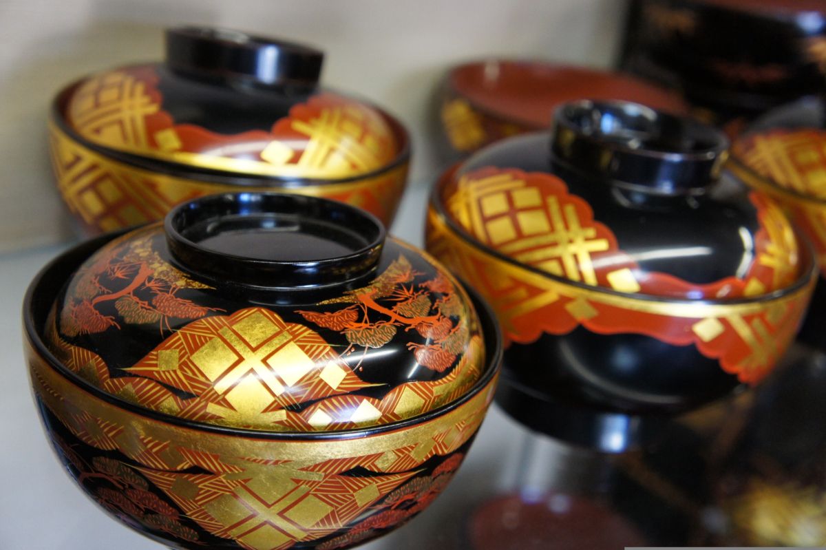 Japanese artisan applying natural urushi lacquer to a handcrafted wooden bowl